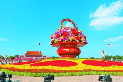     近日，“祝福祖国”巨型花篮在天安门广场正式亮相，为即将来临的国庆佳节增添了喜庆气氛，来自祖国各地的游客纷纷与大花篮合影留念。赵乃明摄/光明图片