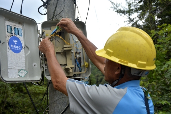 图为中国电信工作人员在检修设备，确保通信网络服务良好。
