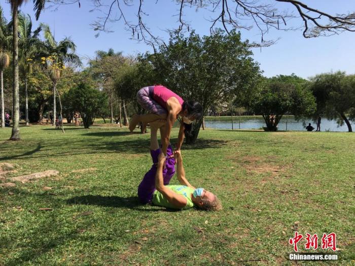 资料图：9月4日，巴西圣保罗，一对夫妇在当地一公园展示顶人技巧。随着新冠疫情日趋减缓，近期巴西圣保罗市各大公园的游人渐多。中新社记者 莫成雄 摄