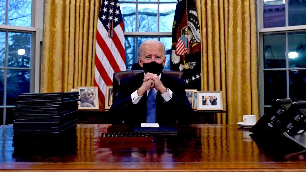 ↑拜登坐在白宫的椭圆形办公室桌前图据AFP