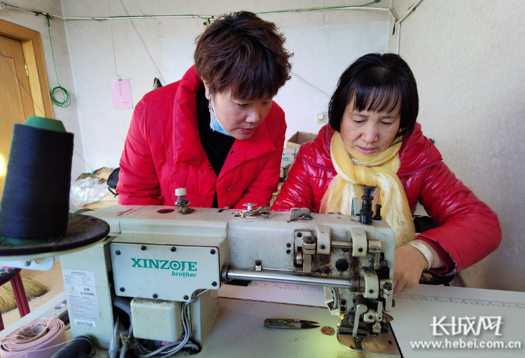 刘小平（左）和正在工作的黄俊兰交流心得体会。长城网记者 郭庆敏 摄