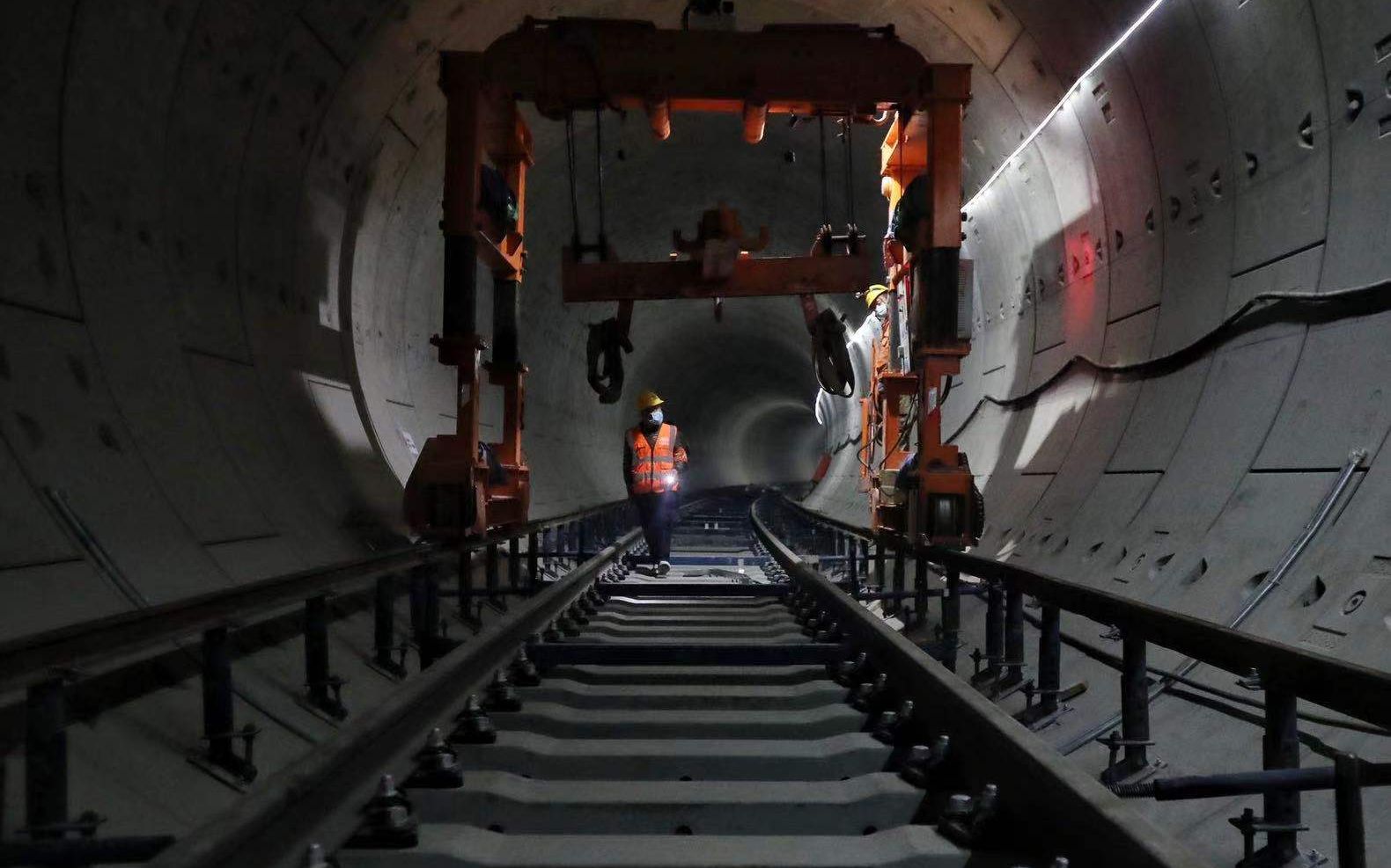 地铁17号线北神树站，工人正在操控吊装钢轨的车辆。摄影/新京报记者王贵彬