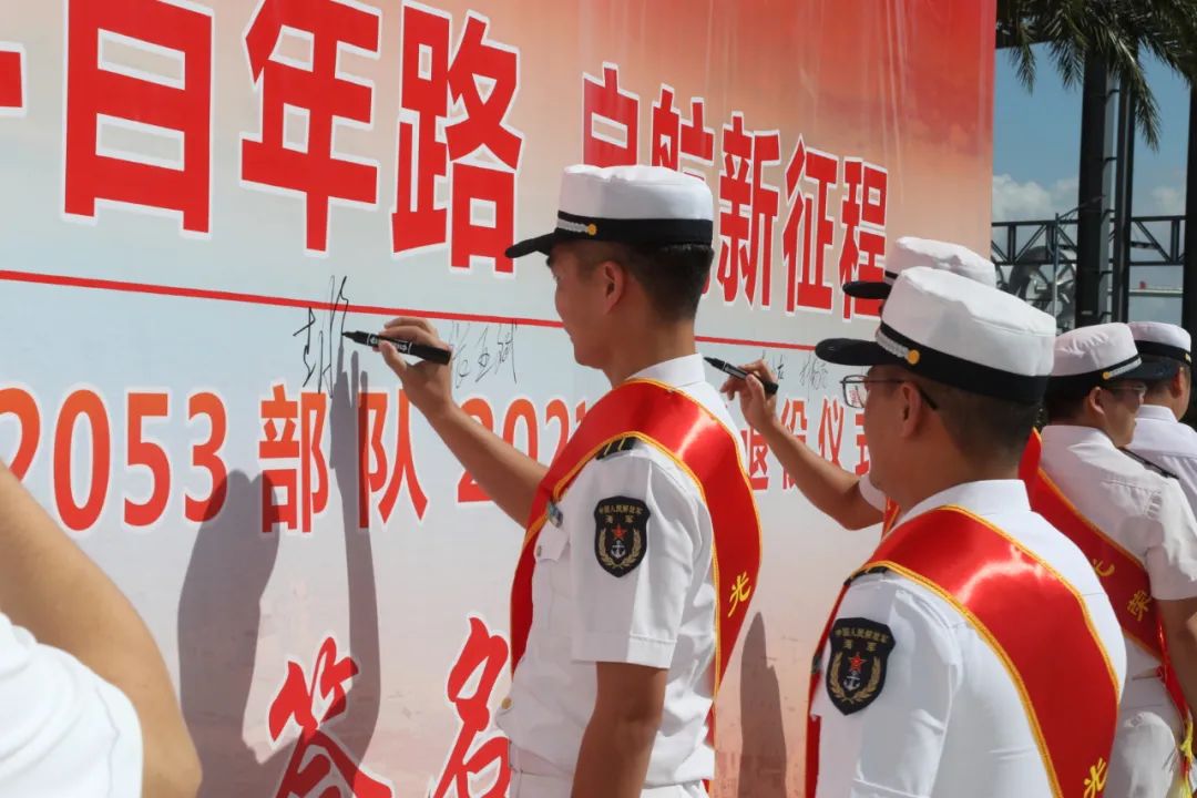 退役军官纷纷来到一面写有"奋斗百年路,启航新征程"10个大字的签名墙