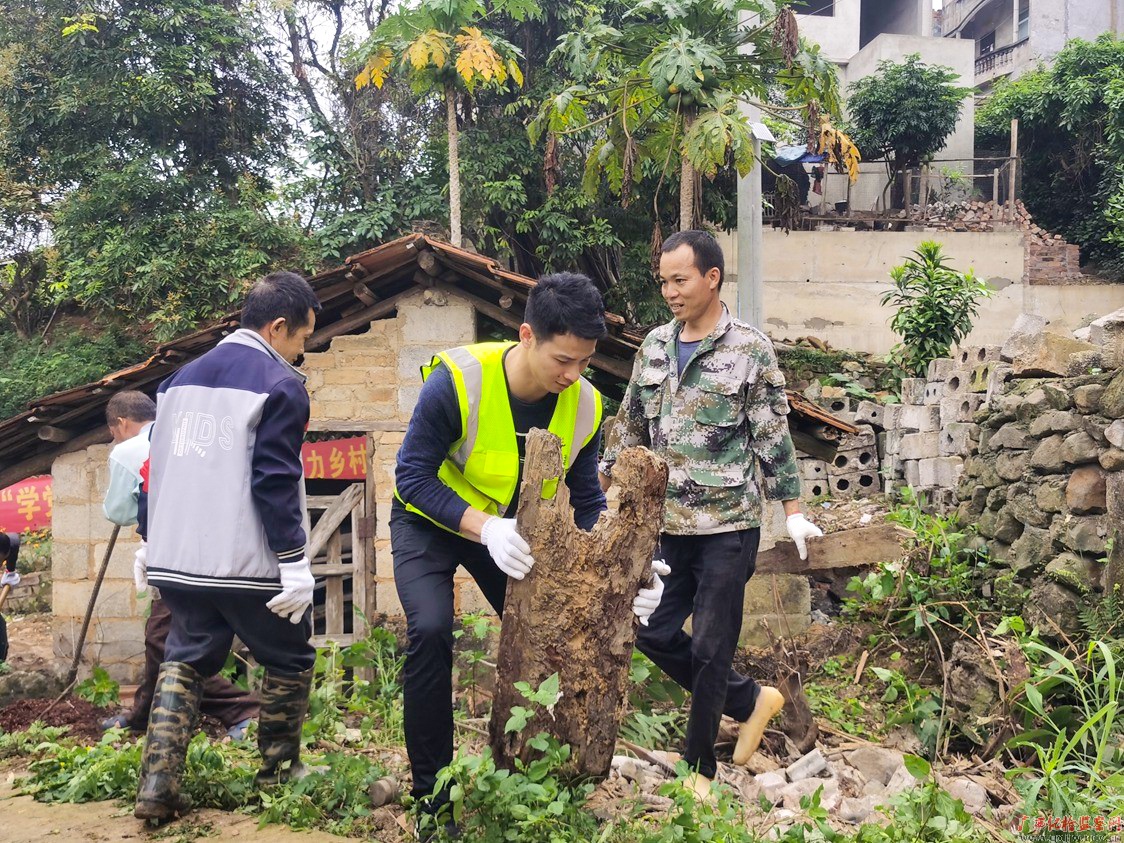 龙州县纪委监委选派上降乡梓丛村驻村工作人员帮助村民清理垃圾杂物，美化村容村貌。（龙州县纪委监委　潘柯君／摄）