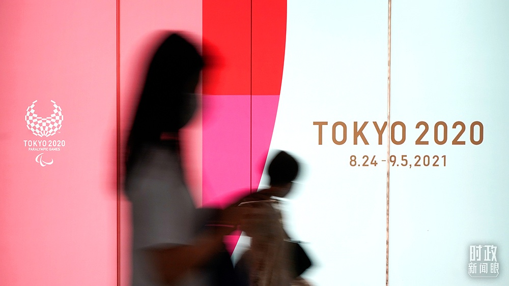 △2021年7月,日本东京,市民经过东京奥运会宣传画。(图/视觉中国)