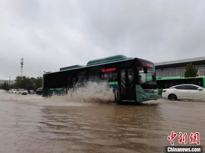 图为郑州市区花园路一辆公交车经过积水路段。　李贵刚　摄