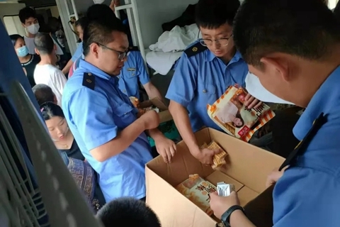 工作人员向乘客发放面包、牛奶、水等物资。图/包头客运段官方微博