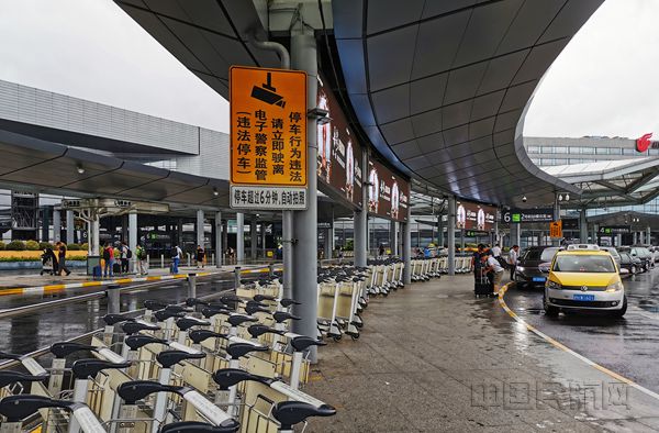 机场在出发层旅客下车出备足行李推车，方便暑运出行旅客(钱擘/摄)