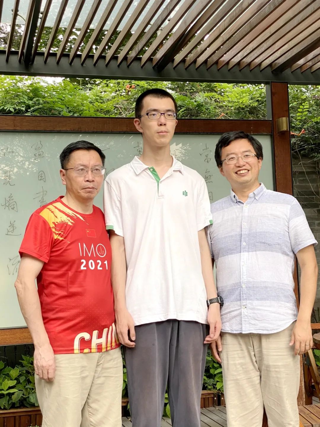  王一川和他的竞赛教练唐立华（左）、中国国家队领队肖梁（右）