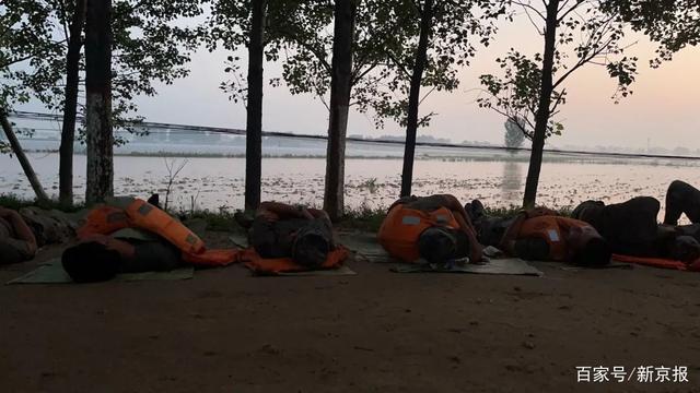 ▲25日凌晨5点，第83集团军某工程防化旅的部分士兵们用纺织袋铺在土路上，躺着休息。新京报记者 王瑞文 摄