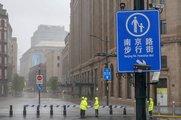 受台风“烟花”影响，昔日热闹的上海南京路步行街变得“安静”。图为7月25日上海南京路步行街设立的警戒线 新华社图