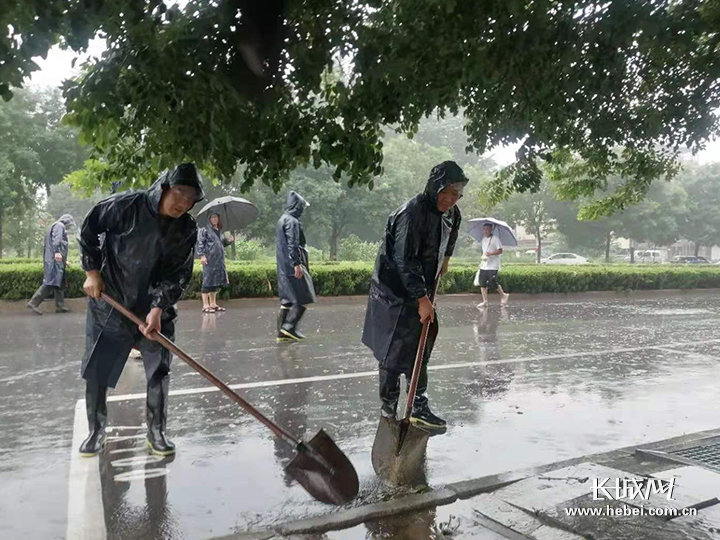 抢险队员正在疏通道路积水。通讯员 供图