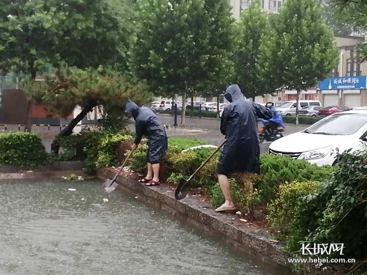 抢险队员正在疏通道路积水。通讯员 供图