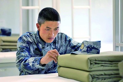黎建在军营宿舍整理床铺。光明图片