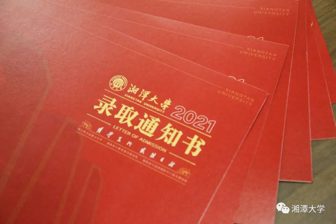 湘潭大学"印章工作人员正在认真核对新生信息录取通知书正在打印请