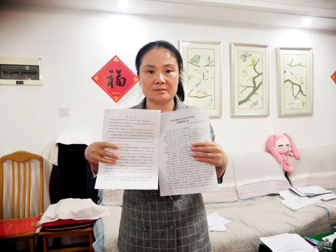  5月19日，原伟东妻子李杰在其天津住所中手持举报信和判决书。摄影/本刊记者 周群峰