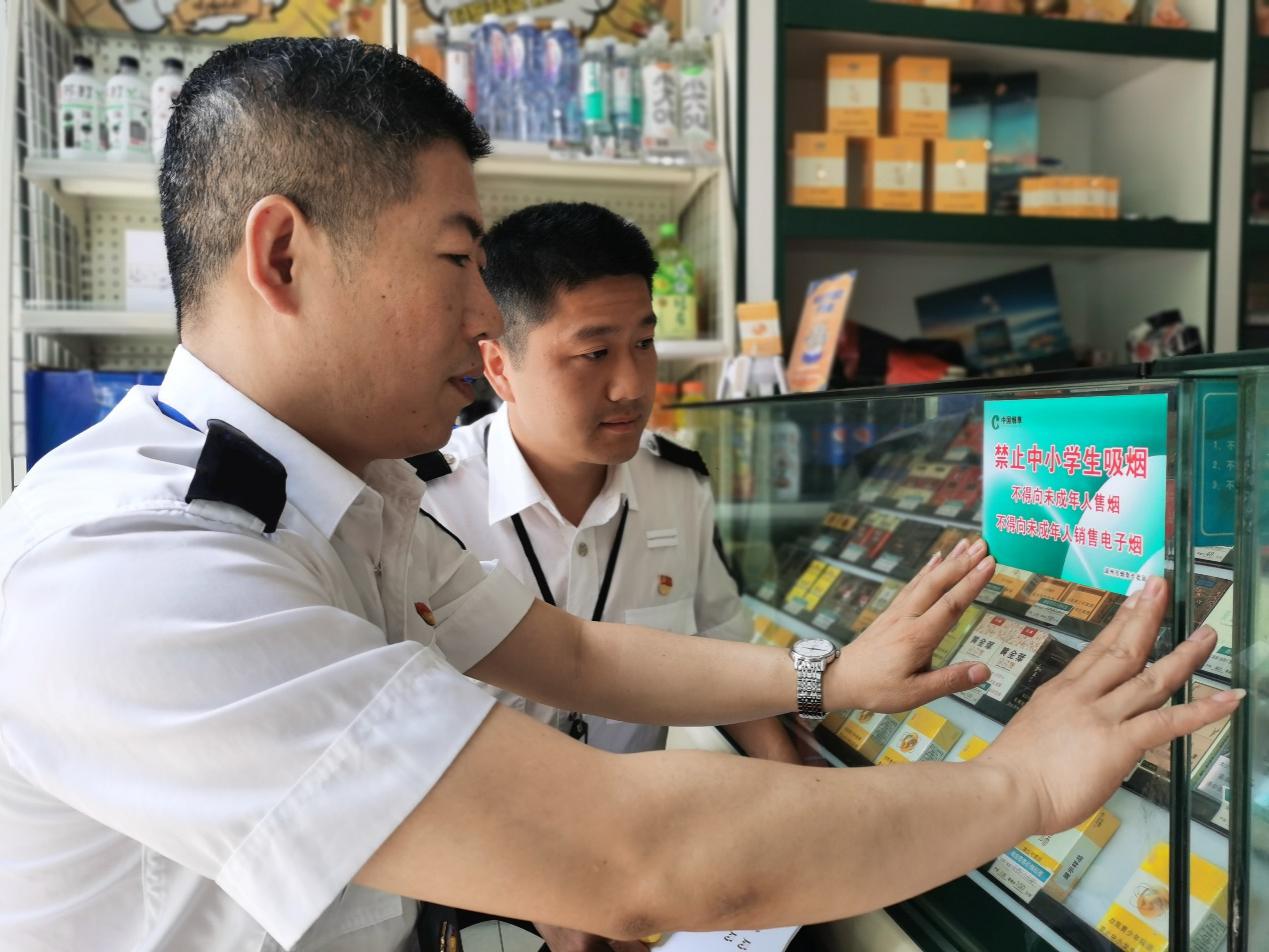 湖州市烟草专卖局执法人员在零售客户店内柜台处张贴"禁止向中小学生