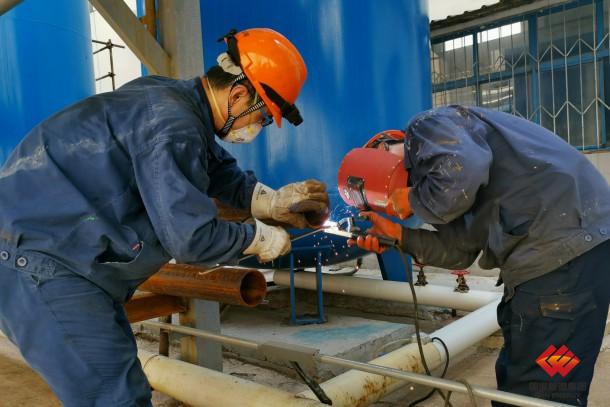 图为锅炉员工检修压缩空气高压冷却器