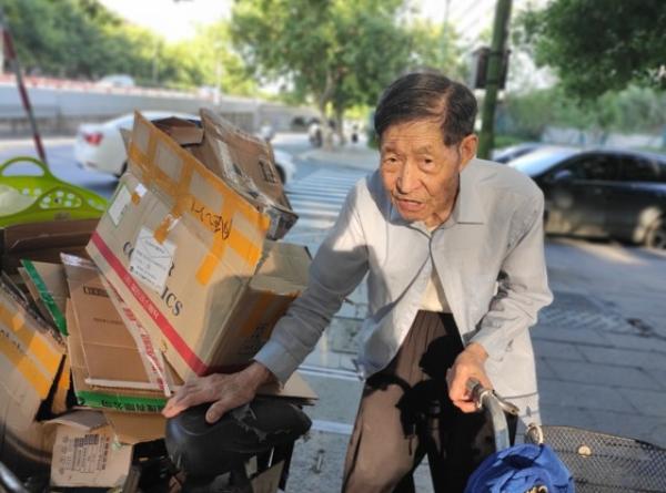 王坤森从邻居家拉回纸箱.实习生熊一鸣图