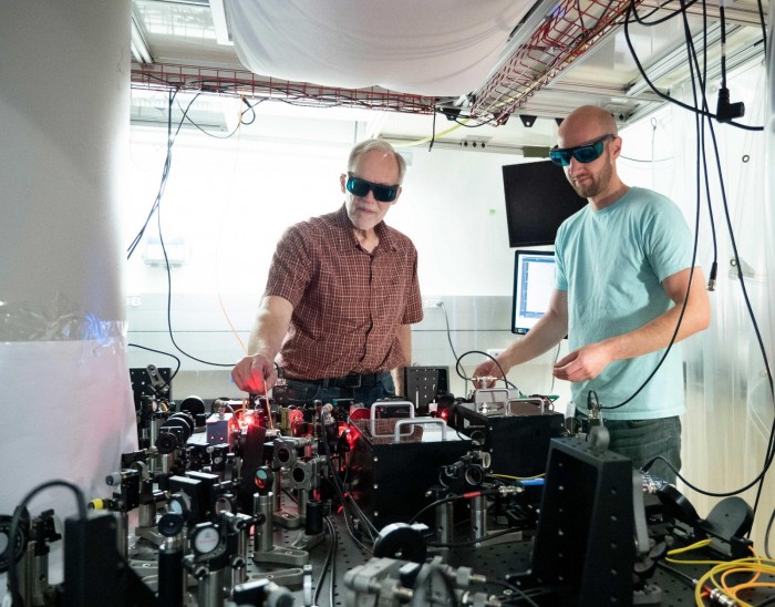 John Bollinger 与 Matt Affolter 在调节激光阵列（图自：NIST）