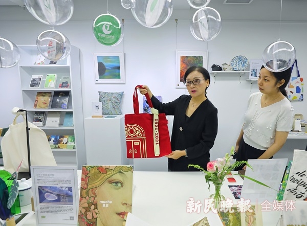 图说:李爽代表(左)展示庆祝建党百年文创产品