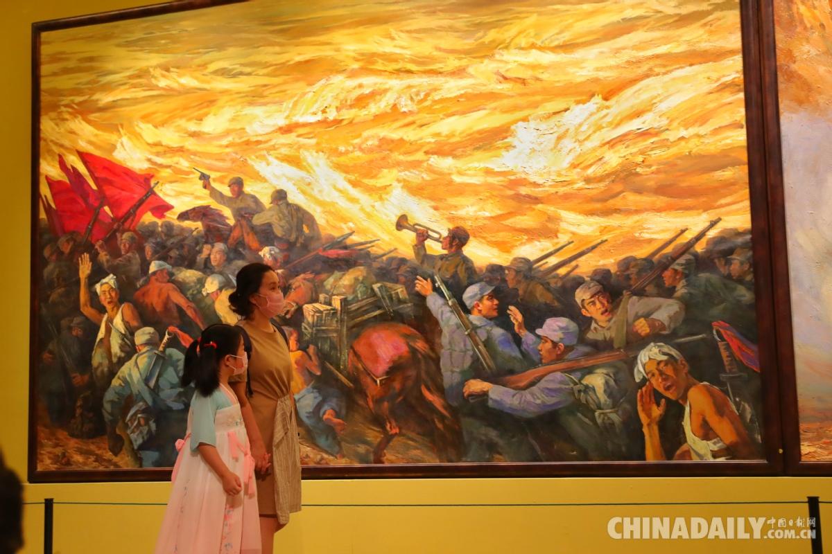 观众欣赏展出的油画《黄河大合唱——流亡·奋起·抗争》(三联画 左).