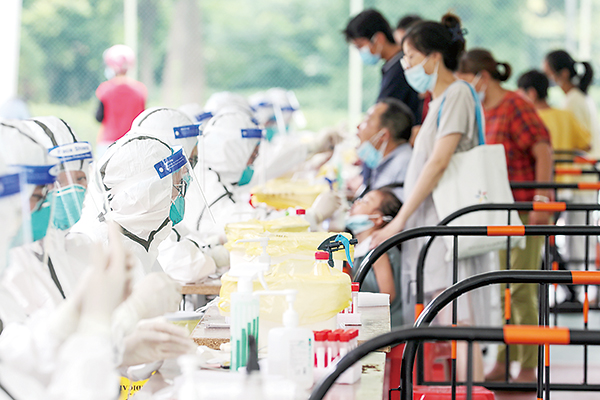 图为医护人员在江苏省扬州市邗江区邗江中学检测点，为居民进行核酸采样。（图片来源：视觉中国）
