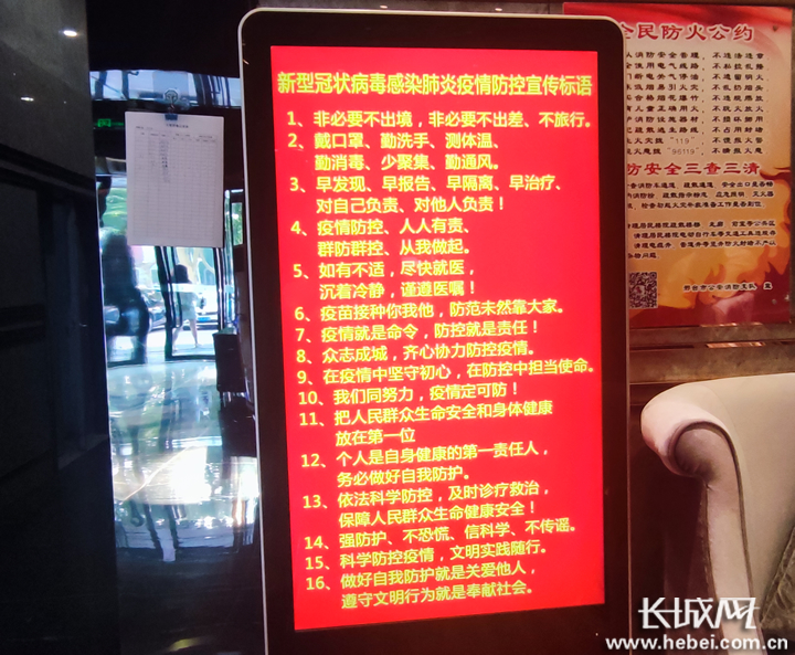 邢台市一酒店大堂内电子屏播放疫情防控宣传标语.