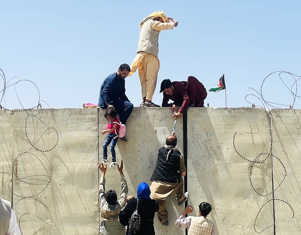 阿富汗民众翻墙进入喀布尔机场