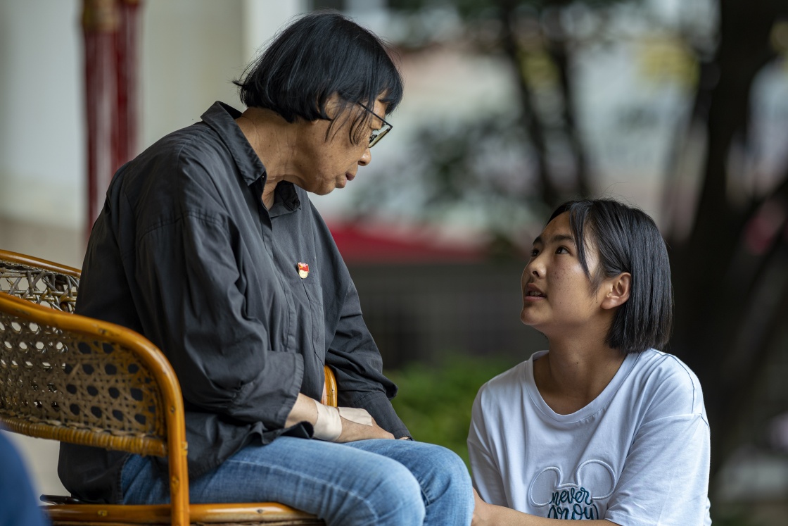  8月23日，杨丽梅（右）与张桂梅在校园内交谈。  新华社 图