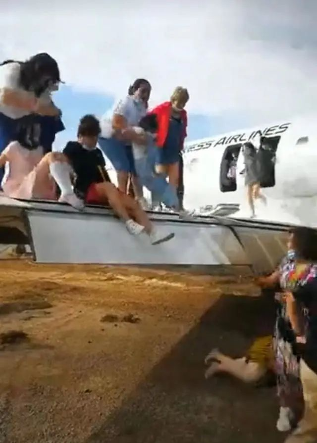 ▲8月29日，乘客通过翼上应急门从华夏航空客机上撤离。图片来源：视频截图