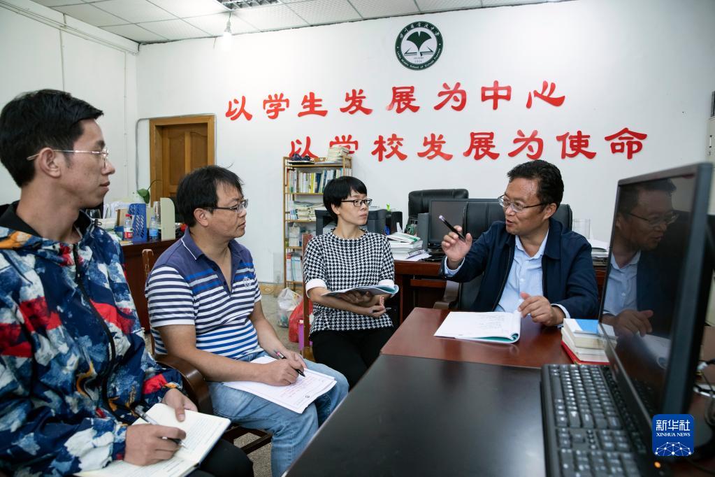 雷波中学校长徐华（右一）与几名即将教高三课程的老师讨论教学及管理工作的重点和难点（8月26日摄）。新华社记者 沈伯韩 摄
