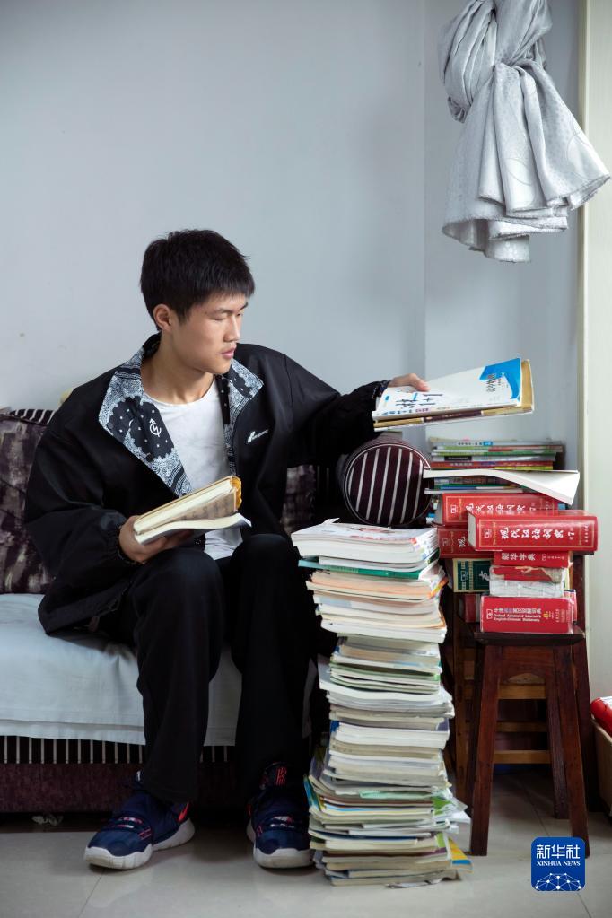 雷波中学高2021届毕业生刘取在雷波县家中收拾部分用过的教科书及教辅材料。他今年被清华大学土木类专业录取（8月26日摄）。新华社记者 沈伯韩 摄