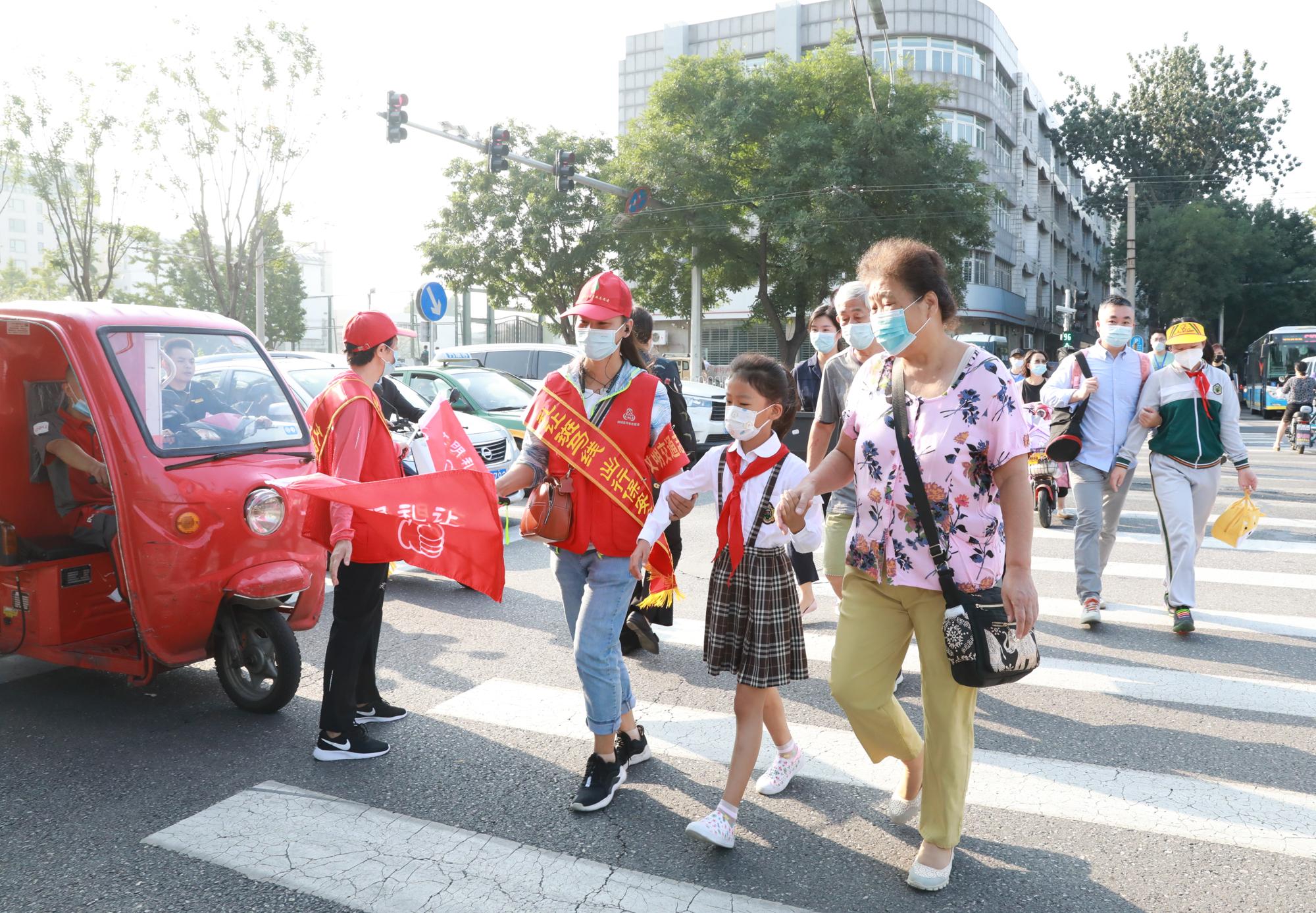 9月1日，什刹海街道礼让斑马线文明引导员在值守中，保障学生安全到校。 方非/摄