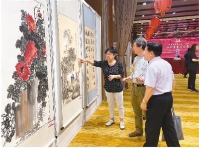 图为到场嘉宾点评展出书画作品。本报记者 金 晨摄