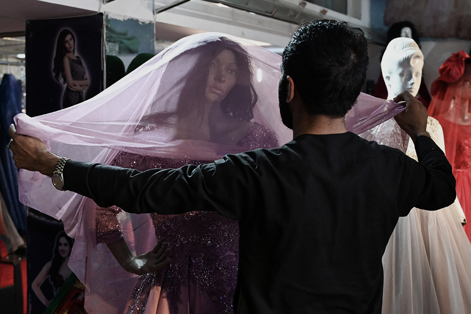 当地时间2021年9月2日,喀布尔,女装店店主给人形模特套上礼服.