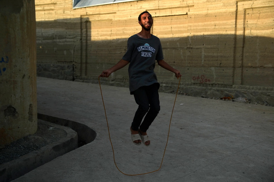 当地时间2021年9月2日,阿富汗年轻人在街上跳绳时,阳光恰巧照射到他面