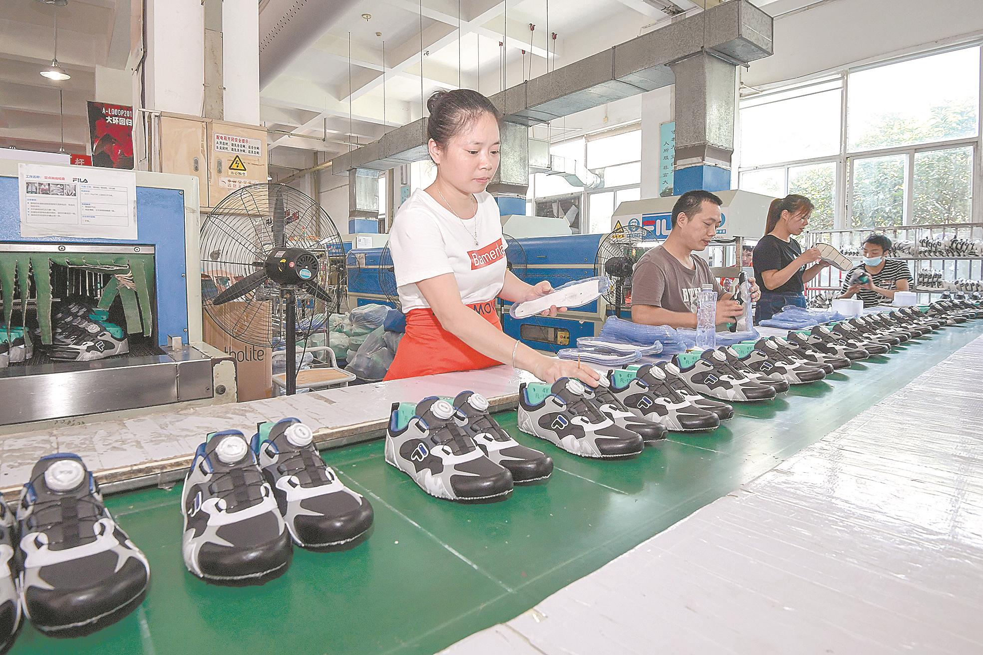 在晋江市的安踏体育公司一车间里，工人在制鞋生产线上操作。本报记者 吴鹏 摄