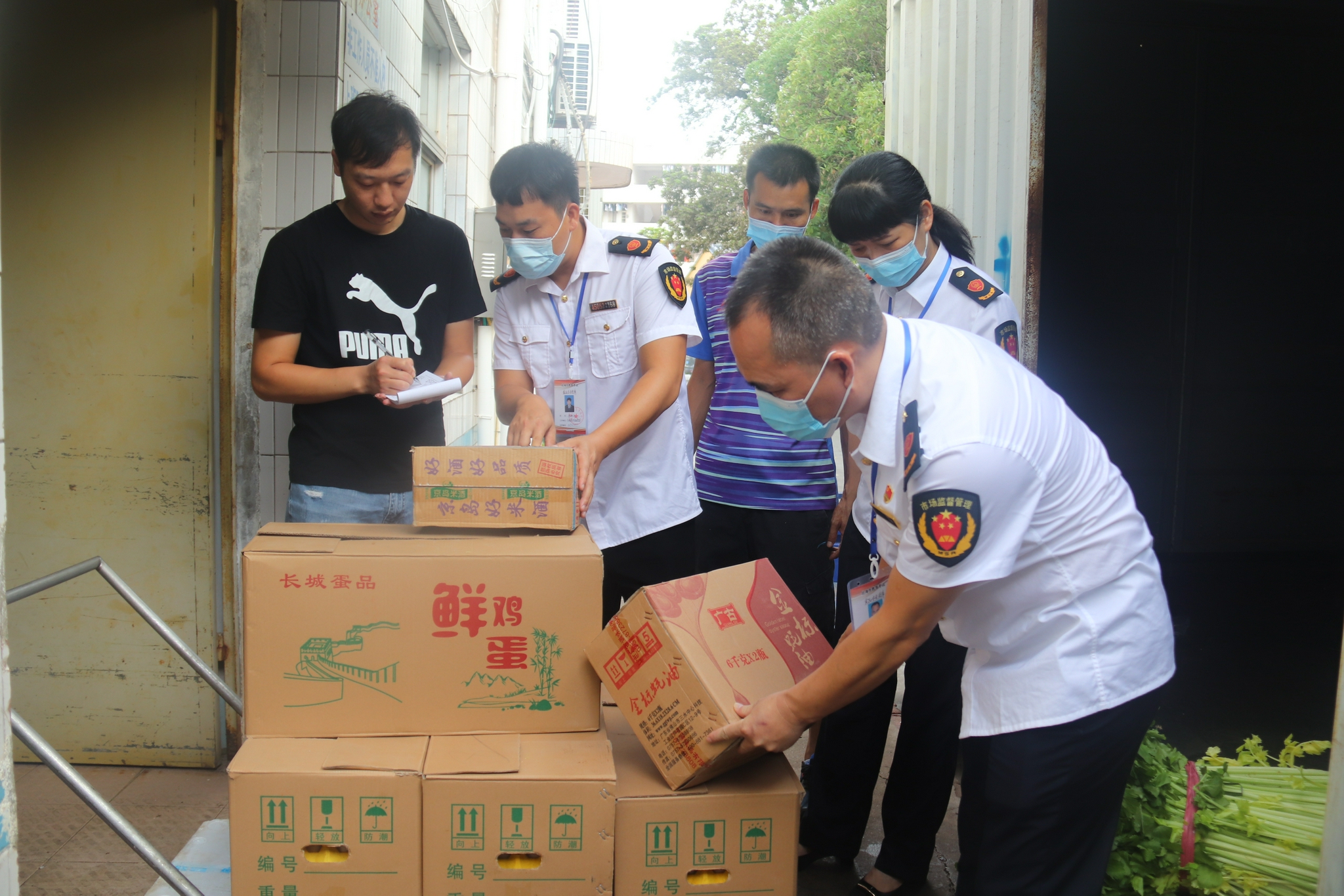 广西合浦县市场监管局执法人员检查学校饭堂食品采购情况.顾艳伟/摄
