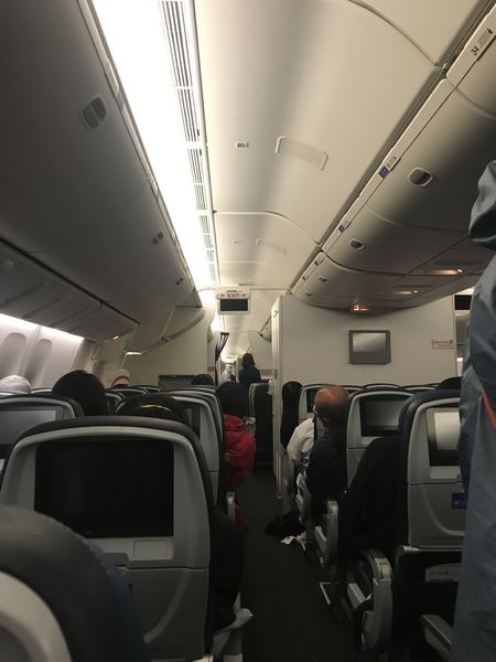 飞机降落机场后,韩先生一家人和其余乘客安静等待工作人员组织下飞 