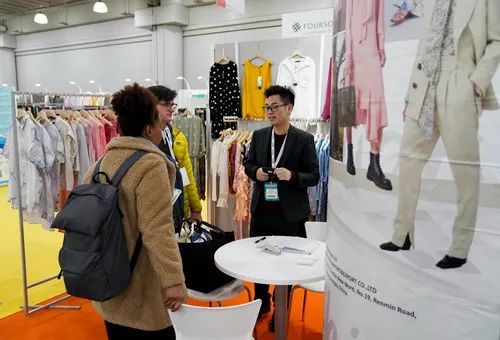 2020年1月21日,在美国纽约举行的第二十一届中国纺织品服装贸易展览会(纽约)春季展上,江苏一家企业的工作人员(右)为访客介绍产品。新华社记者王迎摄