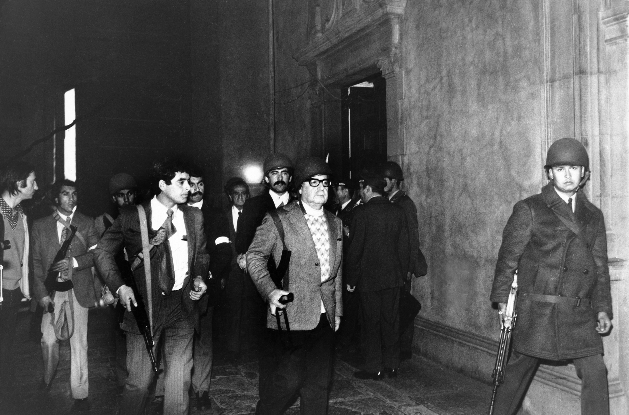 1973年,萨尔瓦多·阿连德头戴钢盔,身背ak47,和他的保镖在总统府中.