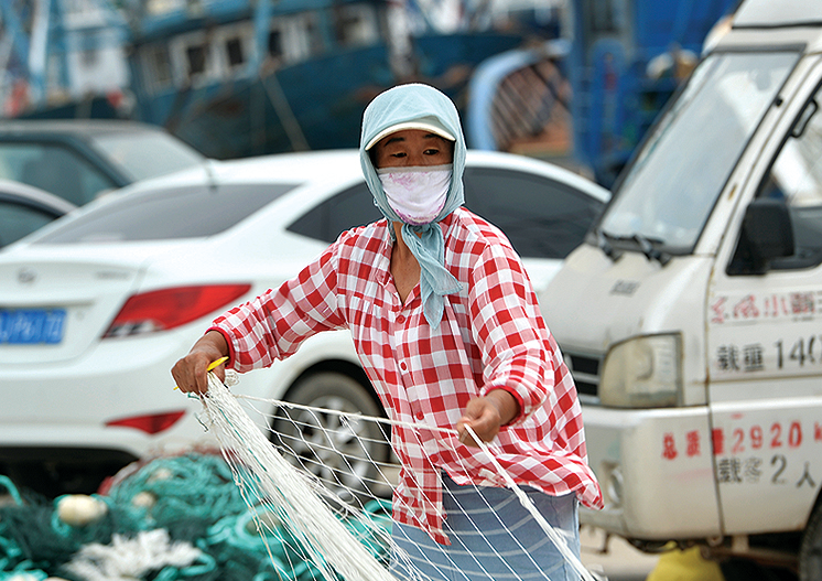 开渔前渔民们抓紧织补渔网.