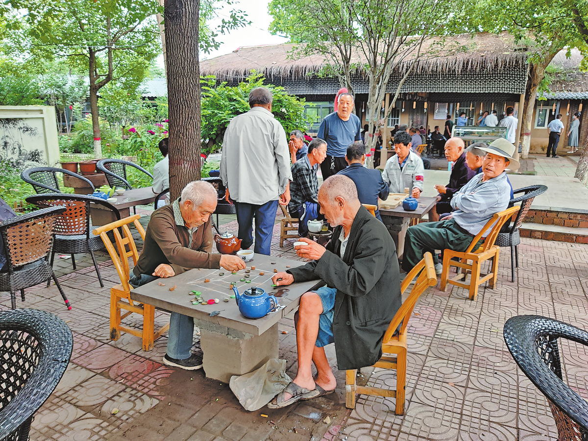 在郏县基层公共卫生服务网点茶食小镇里，老人们聚在一起下棋。（河南报业全媒体记者 张保富 摄）