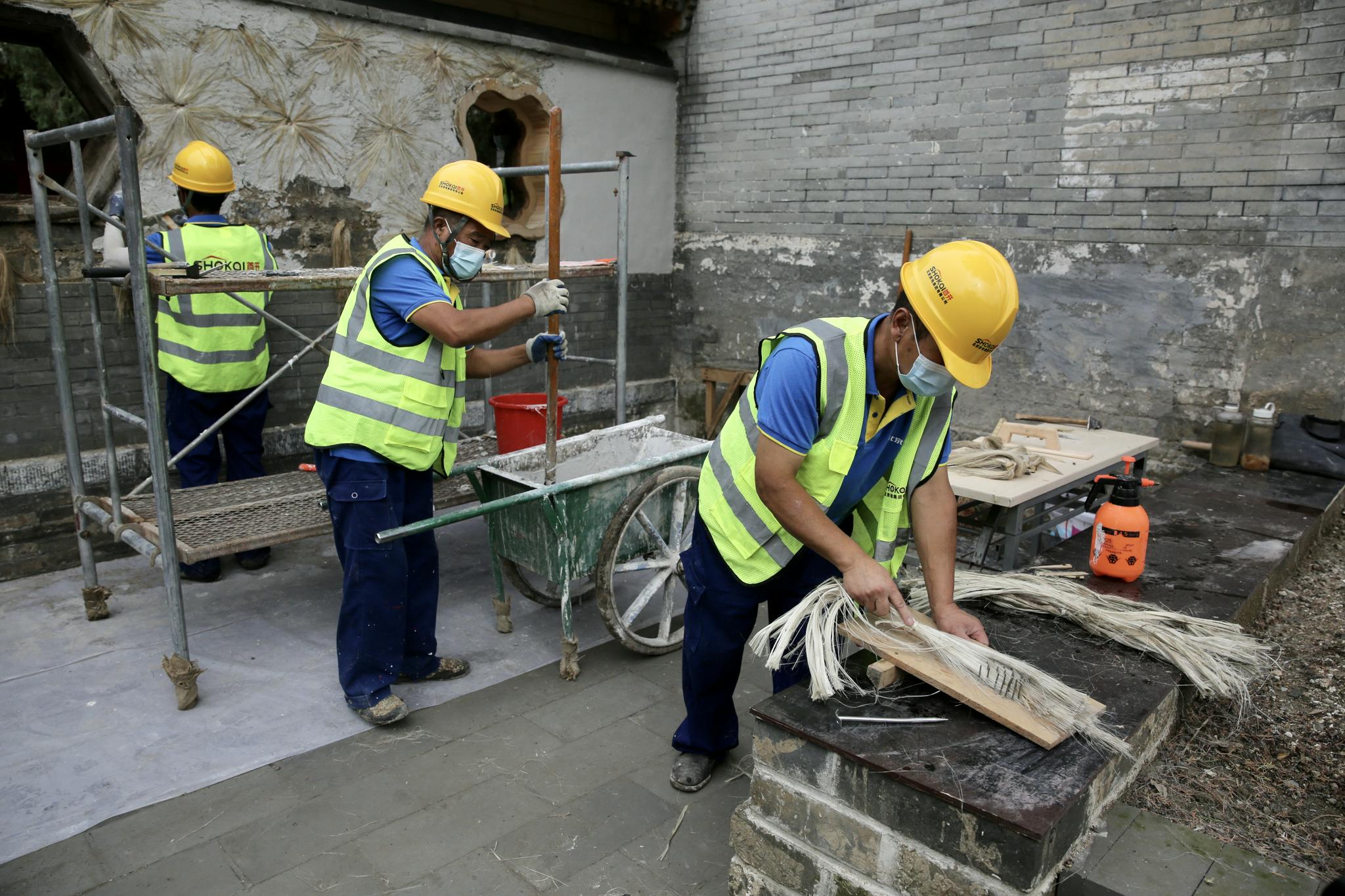 万寿寺二期修缮工地,工人正在对墙体进行修缮,涉及"钉麻揪"等工艺操作