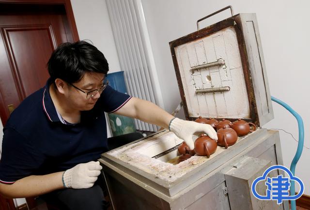 图2周翔将自己的作品小心翼翼的放进电炉进行烧制.