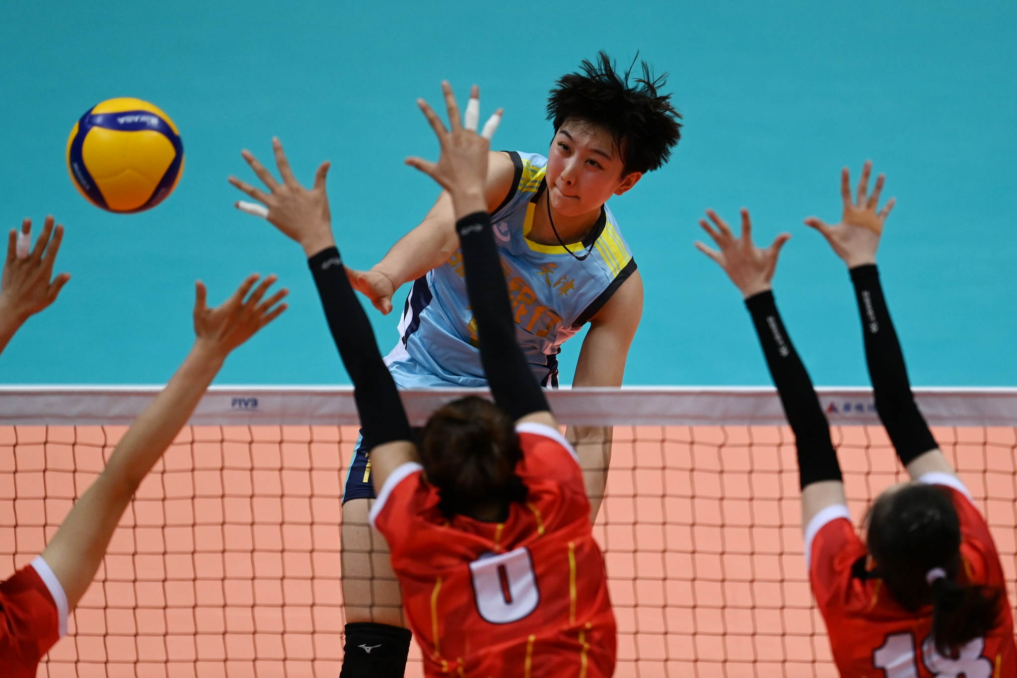 天津队球员陈博雅（蓝衣）在比赛中扣球。（中国日报记者 魏晓昊 摄）