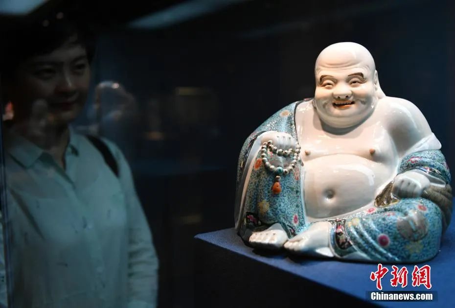 资料图：一名游客观赏香港收藏家的瓷塑藏品《弥勒佛》。中新社记者 张茵 摄