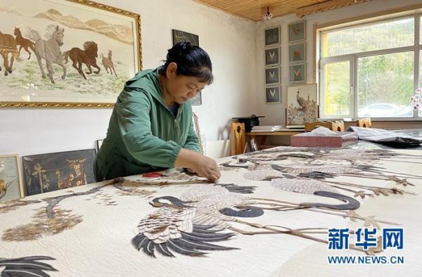 图为当地的手艺人正在制作树皮画。 新华网王莹 摄