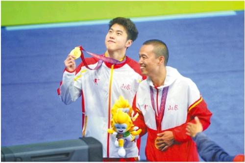 　　记者李勇报道 9月26日，山东选手程龙（左）夺得第十四届全运会男子1500米自由泳金牌。图为程龙和教练在颁奖仪式上。